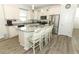 Modern kitchen with white cabinets, granite countertops, stainless steel appliances and center island with barstool seating at 8878 Conway Rd, Polk City, FL 33868