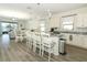 Open-concept kitchen with island seating, stainless steel appliances, and views of the adjacent dining and living areas at 8878 Conway Rd, Polk City, FL 33868