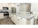 Close-up of kitchen island with granite countertops, white cabinetry, and stainless steel appliances at 8878 Conway Rd, Polk City, FL 33868