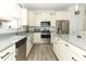 Modern kitchen with white cabinets, stainless steel appliances, and granite countertops at 8878 Conway Rd, Polk City, FL 33868