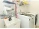 Laundry room with stainless steel appliances, utility sink, tiled backsplash and shelving at 8878 Conway Rd, Polk City, FL 33868