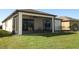 View of the screened patio with ceiling fan and outdoor seating overlooking the lush green lawn at 8878 Conway Rd, Polk City, FL 33868