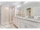 Bathroom featuring double vanities with granite countertops and glass enclosed shower at 9560 Starling Loop, Leesburg, FL 34788