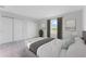 Bedroom with neutral colors, a serene view, double closets, and two windows at 9560 Starling Loop, Leesburg, FL 34788