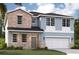 Charming two-story home with stone accents, blue siding and an attached two-car garage at 9560 Starling Loop, Leesburg, FL 34788