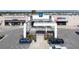 An exterior view of a shopping center with retail stores and a covered entry for shoppers' convenience at 9560 Starling Loop, Leesburg, FL 34788