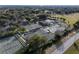 Aerial view showcasing multiple tennis courts surrounded by lush greenery and mature trees at 9560 Starling Loop, Leesburg, FL 34788