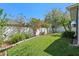 Well-maintained backyard featuring lush green grass, mature trees, and a classic white fence at 9774 Nonacrest Dr, Orlando, FL 32832