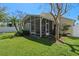 Spacious backyard featuring a screened-in lanai, lush green lawn, and mature trees providing shade and privacy at 9774 Nonacrest Dr, Orlando, FL 32832