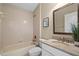 A full bathroom boasts a shower-tub combo and a granite vanity with great lighting and storage space at 9774 Nonacrest Dr, Orlando, FL 32832