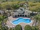 Aerial view of the community pool and lounge area surrounded by lush landscaping and mature palm trees at 9774 Nonacrest Dr, Orlando, FL 32832