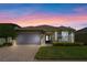 Charming single-story home featuring a two-car garage, well-kept lawn, and a brick driveway at 9774 Nonacrest Dr, Orlando, FL 32832