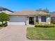 Charming single-story home with a well-maintained lawn, brick driveway, and a two-car garage at 9774 Nonacrest Dr, Orlando, FL 32832