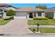 Charming home featuring manicured landscaping, brick driveway, and a two-car garage at 9774 Nonacrest Dr, Orlando, FL 32832