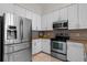 Well-lit kitchen showcasing granite countertops, stainless steel appliances, and ample storage space at 9774 Nonacrest Dr, Orlando, FL 32832