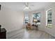 Cozy living room with wood floors, a ceiling fan, and large windows offering plenty of natural light at 9774 Nonacrest Dr, Orlando, FL 32832