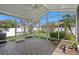 Enclosed screened patio with brick flooring, providing a tranquil view of the lush, fenced backyard at 9774 Nonacrest Dr, Orlando, FL 32832