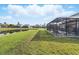 Spacious backyard with a screened-in pool area, offering serene views of the pond at 1207 Winding Cypress Ct, Kissimmee, FL 34746