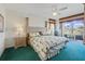 Comfortable bedroom with plush carpet, a ceiling fan, and a sliding glass door leading to a balcony at 1207 Winding Cypress Ct, Kissimmee, FL 34746