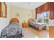 A well-lit bedroom with two twin beds, neutral paint and tile floor at 1207 Winding Cypress Ct, Kissimmee, FL 34746