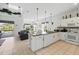 Open-concept kitchen with white cabinetry, black countertops, and a view of the living area at 1207 Winding Cypress Ct, Kissimmee, FL 34746