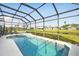 Sparkling pool and spa in screened enclosure with views of the green space at 1207 Winding Cypress Ct, Kissimmee, FL 34746