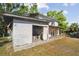 Exterior showing a partially open garage, covered patio, and two-story house at 100 N Main St, Winter Garden, FL 34787