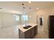 The modern kitchen features an island, stainless steel appliances, and sleek gray cabinets at 10079 Memoir Ave, Winter Garden, FL 34787