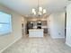 Open-concept kitchen and dining area filled with natural light, gray cabinets, and a tile floor at 10079 Memoir Ave, Winter Garden, FL 34787
