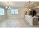 A modern kitchen island and dining space filled with plenty of natural light and gray cabinets at 10079 Memoir Ave, Winter Garden, FL 34787