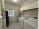 A functional laundry room features a modern washer and dryer and storage shelves at 10079 Memoir Ave, Winter Garden, FL 34787