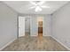 An empty bedroom with wood-look floors, a ceiling fan, a closet and an en suite bathroom at 11568 Westwood Blvd # 1021, Orlando, FL 32821