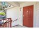 Close-up of a condo's main entrance highlighting the red door and nearby parking at 11568 Westwood Blvd # 1021, Orlando, FL 32821