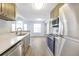 Updated kitchen with stainless steel appliances, light wood cabinets and light countertops overlooking living area at 11568 Westwood Blvd # 1021, Orlando, FL 32821