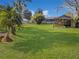 Expansive back yard featuring lush green lawn and mature trees, offering ample space for outdoor activities at 11847 Ocklawaha Dr, Leesburg, FL 34788