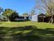 Lush backyard features a storage shed and screened patio, perfect for outdoor activities and relaxation at 11847 Ocklawaha Dr, Leesburg, FL 34788