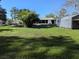 Spacious backyard with mature trees, a versatile shed, and screened patio, perfect for outdoor activities and storage at 11847 Ocklawaha Dr, Leesburg, FL 34788