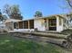 Rear exterior showcasing a screened-in porch, neutral siding, and an open patio area at 11847 Ocklawaha Dr, Leesburg, FL 34788