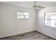 This bedroom features new flooring, light colored walls and ceilings, and two sunny windows at 11847 Ocklawaha Dr, Leesburg, FL 34788