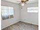 This bedroom features new flooring, light colored walls and ceilings, and two sunny windows at 11847 Ocklawaha Dr, Leesburg, FL 34788