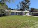 Charming single-story home with a lush green lawn and mature trees, providing a serene curb appeal at 11847 Ocklawaha Dr, Leesburg, FL 34788
