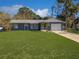 Charming single-story home with a lush green lawn and attached two-car garage at 11847 Ocklawaha Dr, Leesburg, FL 34788