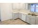 Clean kitchen featuring white cabinets, updated counter tops, and modern appliances at 11847 Ocklawaha Dr, Leesburg, FL 34788
