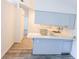 Open-concept kitchen with white cabinets, modern appliances, and laminate flooring at 11847 Ocklawaha Dr, Leesburg, FL 34788