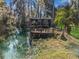 Picturesque view of the serene waterfront, showcasing a covered dock and lush landscape at 11847 Ocklawaha Dr, Leesburg, FL 34788