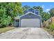 Charming home with a two-car garage and driveway, surrounded by mature trees and landscaping at 119 Winterglen Dr Dr, Sanford, FL 32771