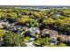Aerial view of a home with a large yard, screened-in pool, and a beautiful lake in the background at 1367 Saddleridge Dr, Orlando, FL 32835
