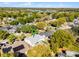 Aerial view of houses in a neighborhood, surrounded by lush greenery and a distant lake with a green pin at 1367 Saddleridge Dr, Orlando, FL 32835