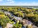 Aerial view showcases the neighborhood with lush greenery and a lake in the distance at 1367 Saddleridge Dr, Orlando, FL 32835