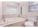 This bathroom contains a large white tub, window, and white toilet at 1367 Saddleridge Dr, Orlando, FL 32835